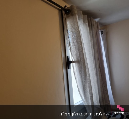 חלון עם וילון שקוף ומוט תלייה